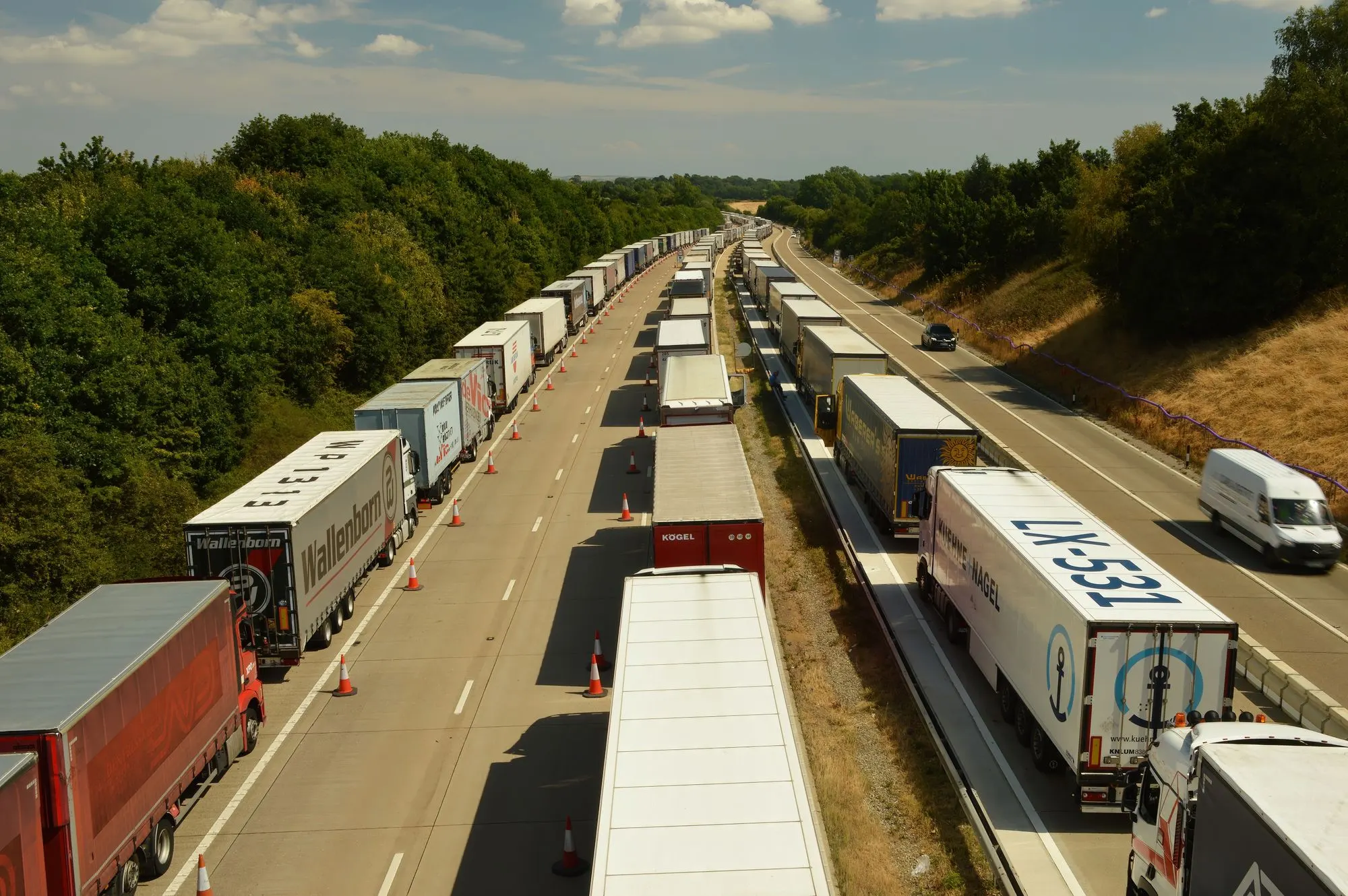 A high-angle view of freight trucks and trailers on a busy highway