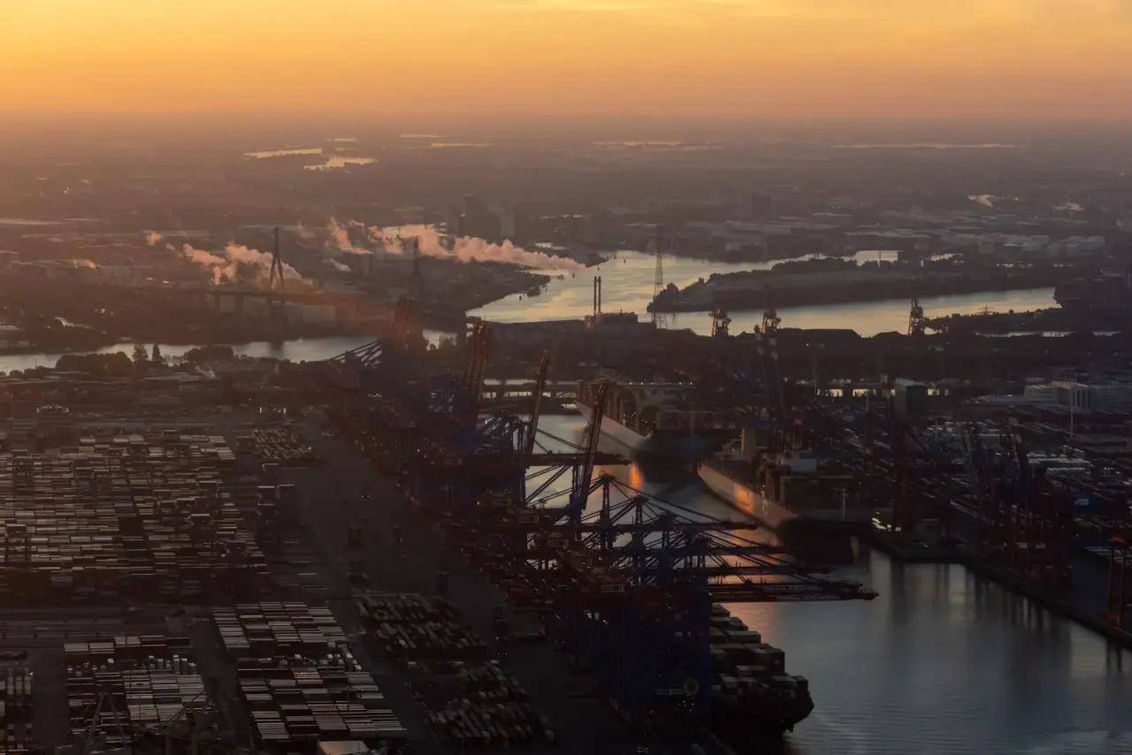 An aerial view of a container terminal and cranes at dusk