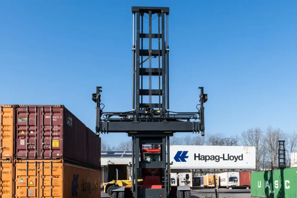 A reach stacker handling shipping containers in a clearing yard