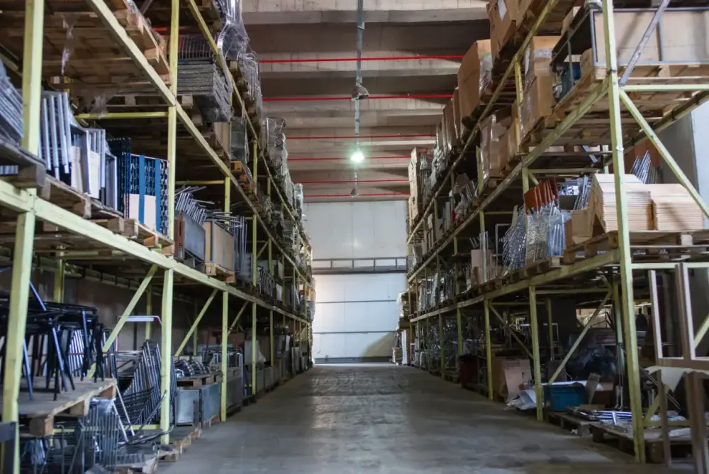 A wide aisle inside a stocked logistics warehouse